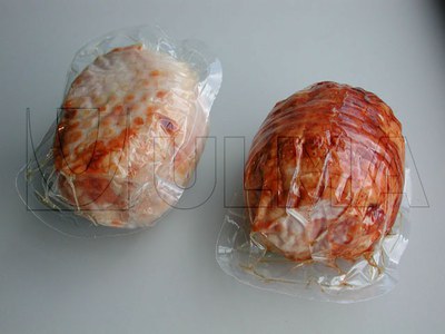 Faszerowany kurczak i porcje polędwicy pakowane próżniowo w folię miękką na maszynie termoformującej.