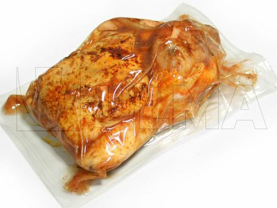 Gorący pieczony kurczak (90C) pakowany próżniowo w folię miękką na maszynie termoformującej.