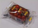 Pomidory malinowe pakowane na tackach na poziomej maszynie pakującej (HFFS).